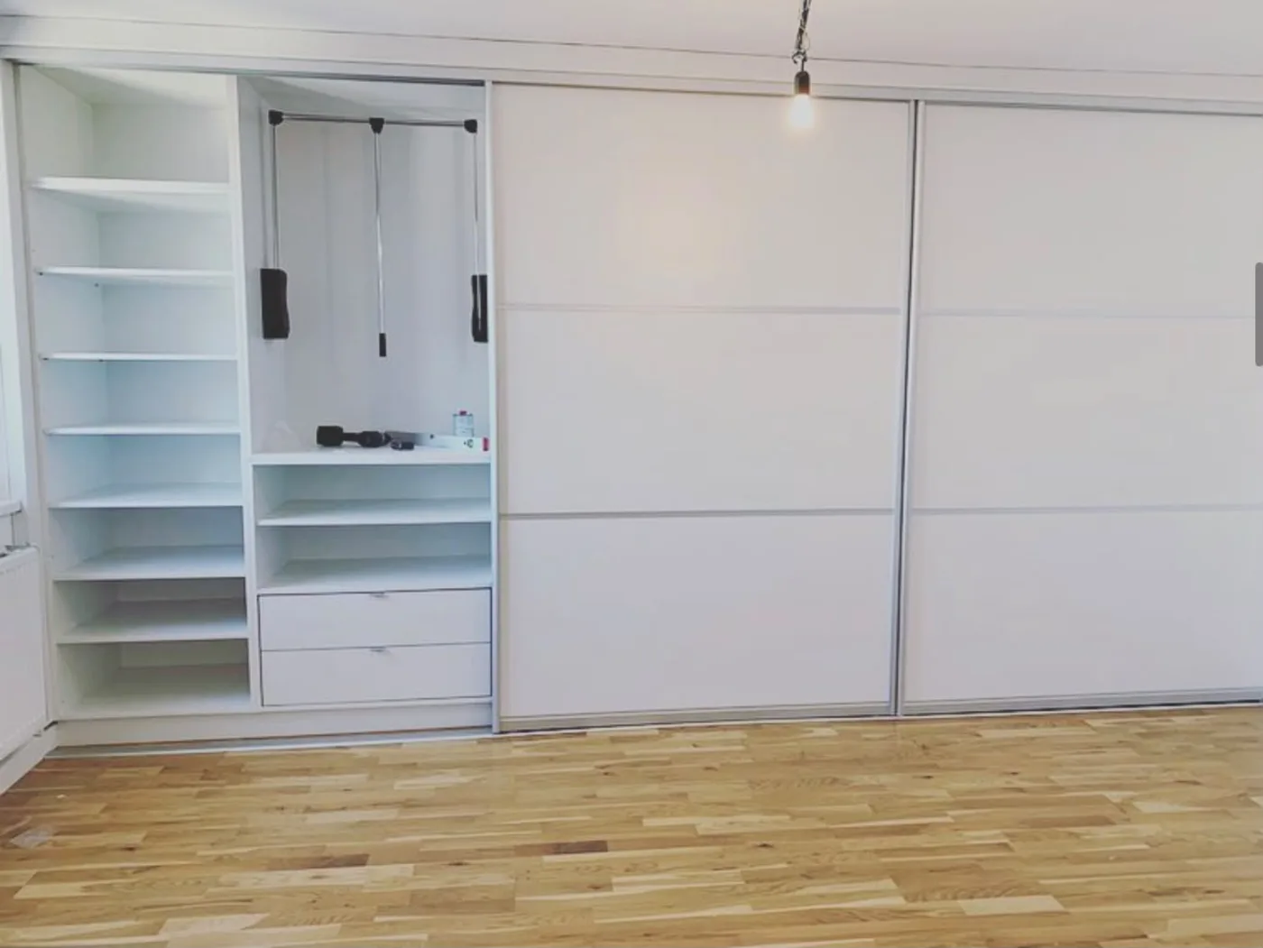 Weißer Einbauschrank mit Schiebetüren und offener Inneneinteilung