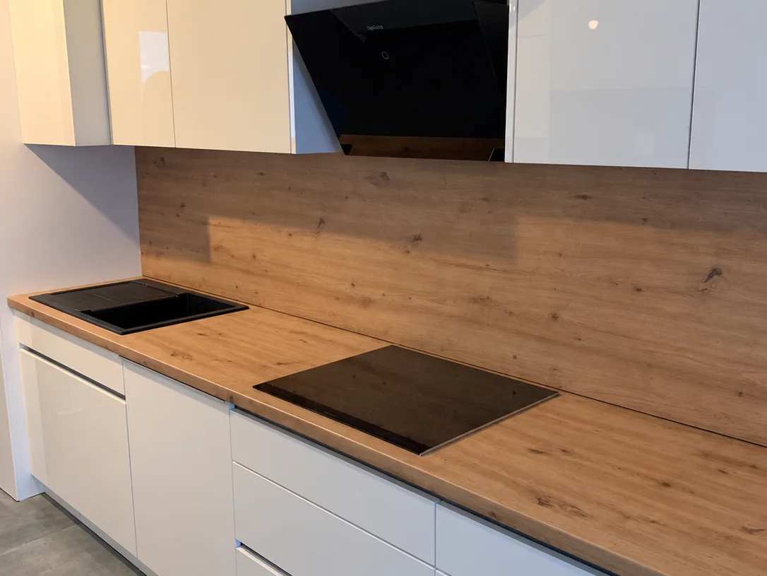 Grifflose weiße Küche mit Arbeitsplatte und Rückwand in Eichenoptik